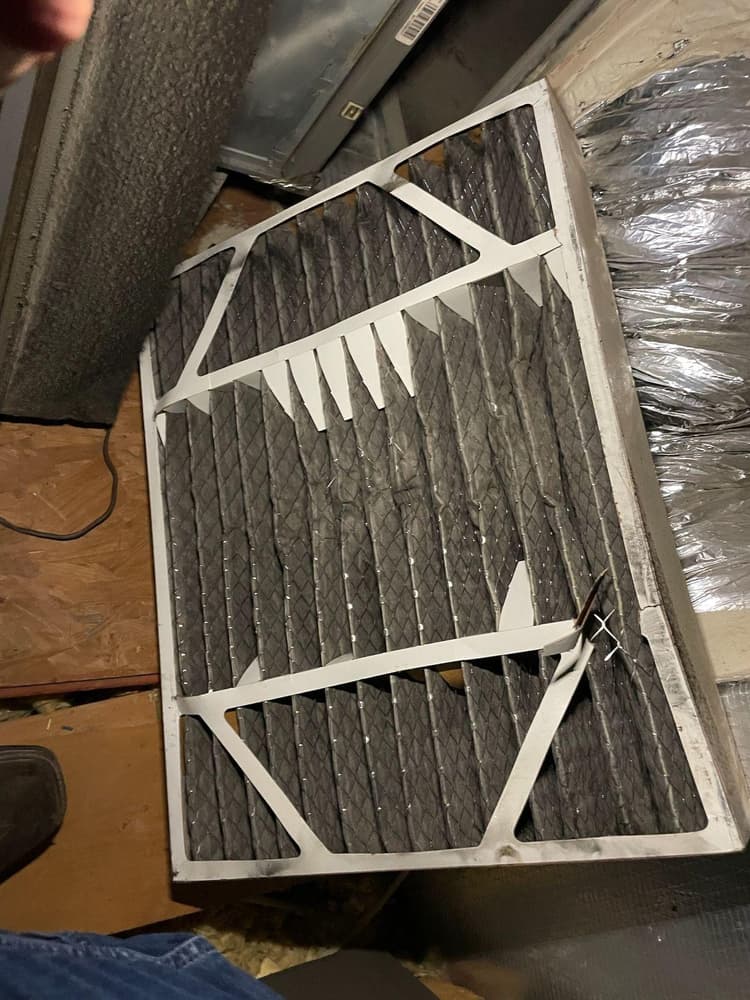 Dirty clogged HVAC air filter being removed during maintenance at San Antonio home