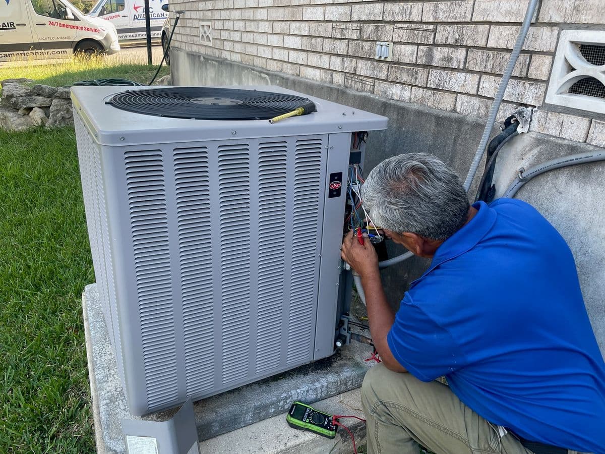 AC American Air technician running electrical diagnostics on residential condenser with multimeter in San Antonio